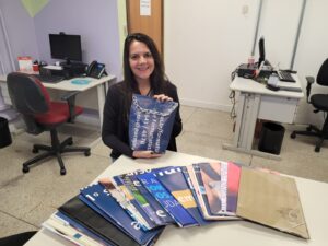 Imagem da instrutora Ana Luiza expondo itens produzidos com banners 